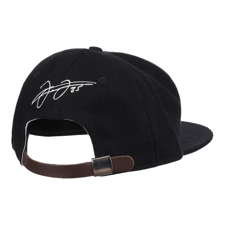 The Ebbets Field Flannels Frank Thomas Signature Series Ballcap in black is shown from the back, highlighting its brown adjustable strap with metal clasp and a white embroidered Frank Thomas signature on the rear panel.