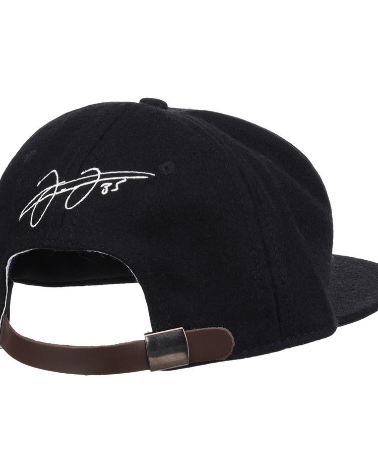 The Ebbets Field Flannels Frank Thomas Signature Series Ballcap in black is shown from the back, highlighting its brown adjustable strap with metal clasp and a white embroidered Frank Thomas signature on the rear panel.