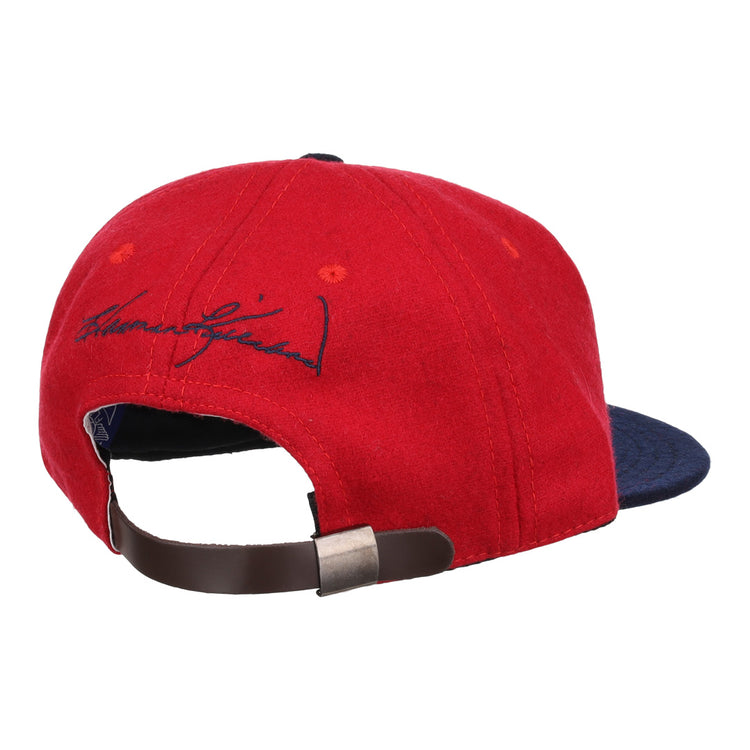 The Ebbets Field Flannels Harmon Killebrew Signature Series Ballcap, in red and navy vintage wool, is shown from the back with a brown adjustable strap, metal clasp, and black signature embroidery above the opening.