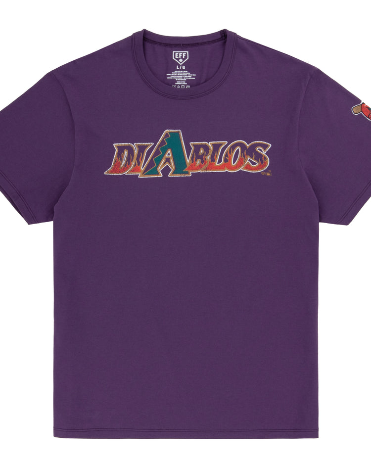 The Ebbets Field Flannels El Paso Diablos EFF MiLB Vintage T-Shirt is a purple premium cotton tee with Diablos in stylized chest text, a graphic logo as the letter A, and a colorful left sleeve patch inspired by vintage minor league shirts.
