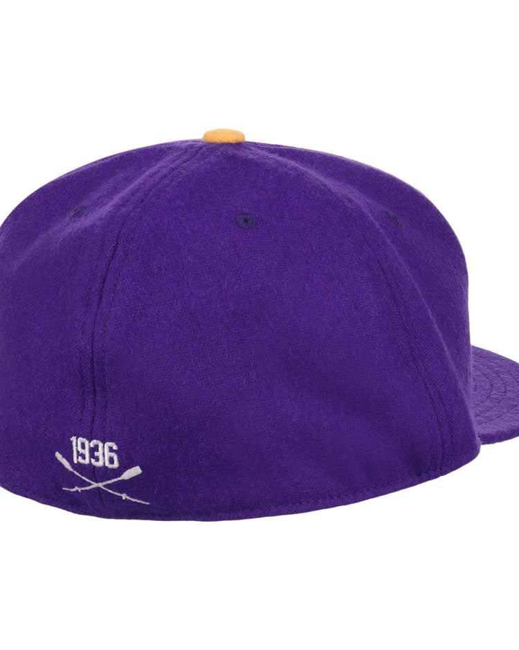 The EFF University of Washington 1936 Rowing Vintage Ballcap features purple wool, a yellow top button, and 1936 with crossed bats embroidered in white on the back—a true collectible for UW fans.