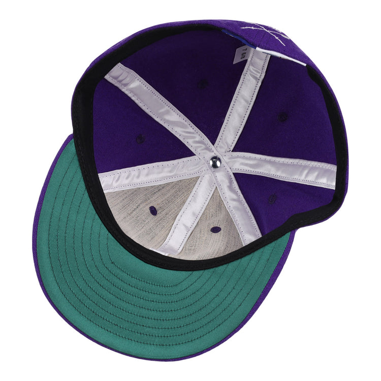 A top-down view of the EFF University of Washington 1936 Rowing Vintage Ballcap shows its purple wool, green brim, white seams, metal button, and black edge lining—an iconic tribute to Husky history.