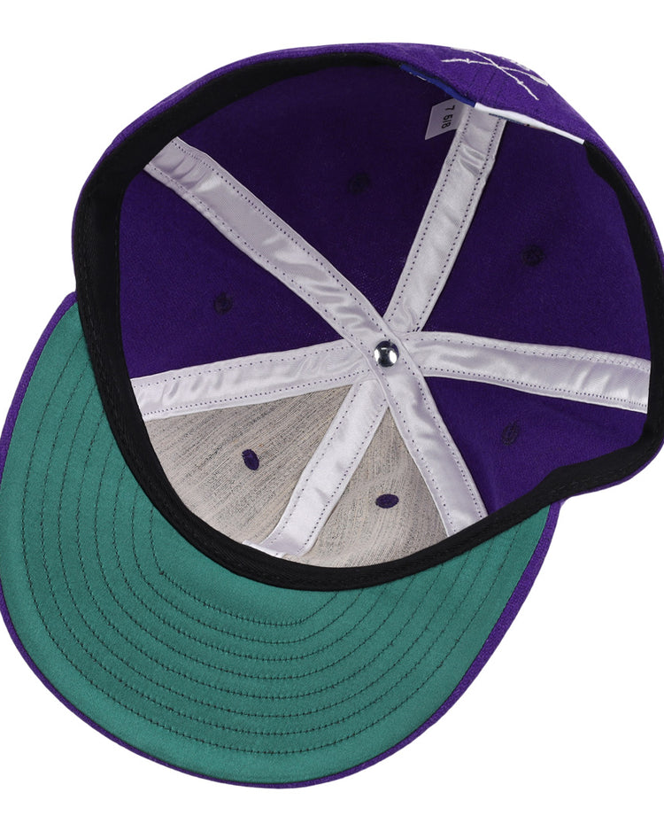 A top-down view of the EFF University of Washington 1936 Rowing Vintage Ballcap shows its purple wool, green brim, white seams, metal button, and black edge lining—an iconic tribute to Husky history.