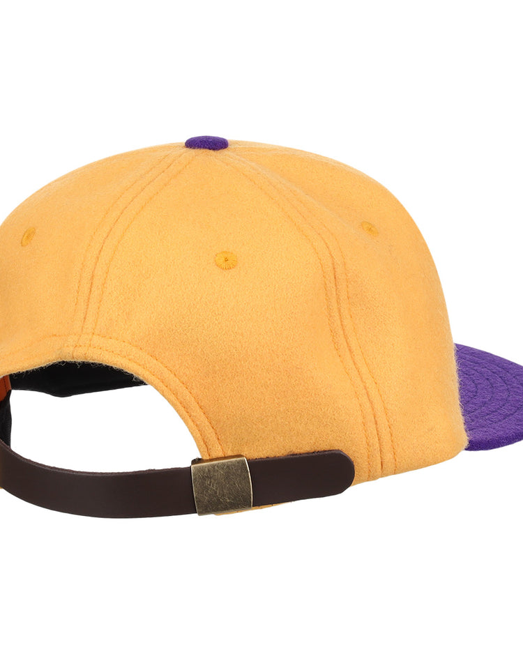 The EFF University of Washington 1936 Rowing Vintage Ballcap in gold features a purple brim and an adjustable dark brown strap with a brass buckle, shown here from the back.
