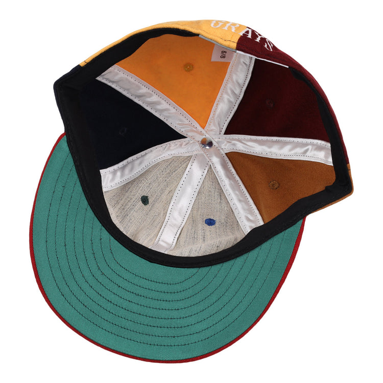 The underside of the EFF Homestead Grays Vintage Inspired Pinwheel Ballcap features six multicolored panels with white seams, a green brim, and red trim. The visible size tag celebrates classic Negro National League style.