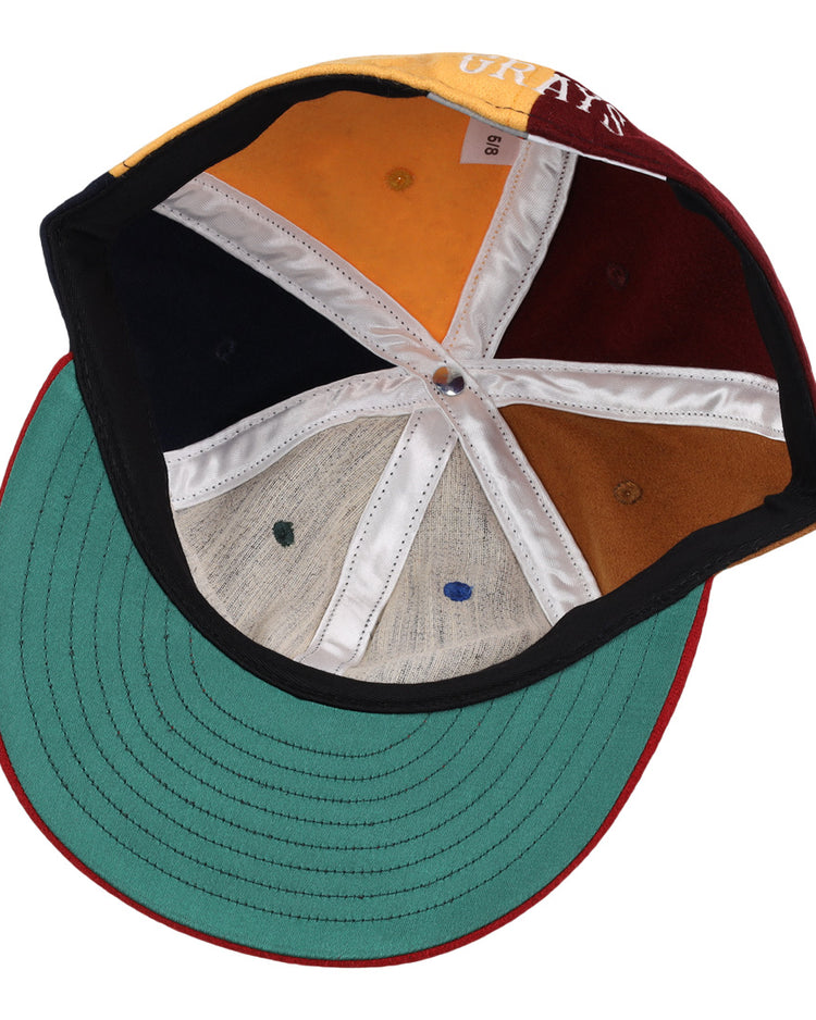 The underside of the EFF Homestead Grays Vintage Inspired Pinwheel Ballcap features six multicolored panels with white seams, a green brim, and red trim. The visible size tag celebrates classic Negro National League style.