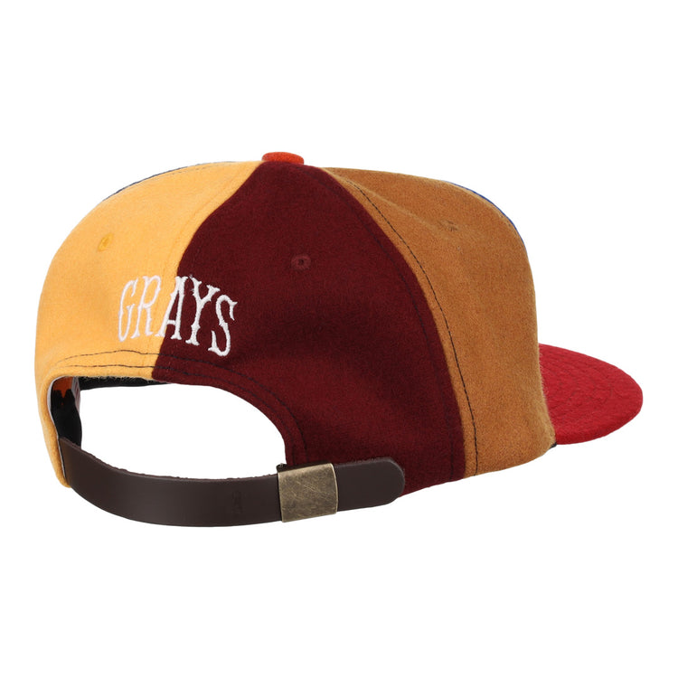 The EFF Homestead Grays Vintage Inspired Pinwheel Ballcap features yellow, burgundy, and brown panels, white “GRAYS” text on the back, and an adjustable brown strap with brass buckle to honor the legacy of the original cap.