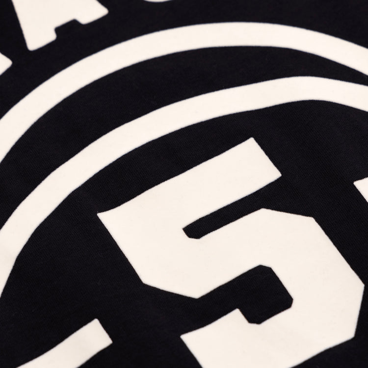 Close-up of white block numbers and curved lines on the Black Fives T-Shirt by Ebbets Field Flannels, printed on black fabric. The visible number is 5.