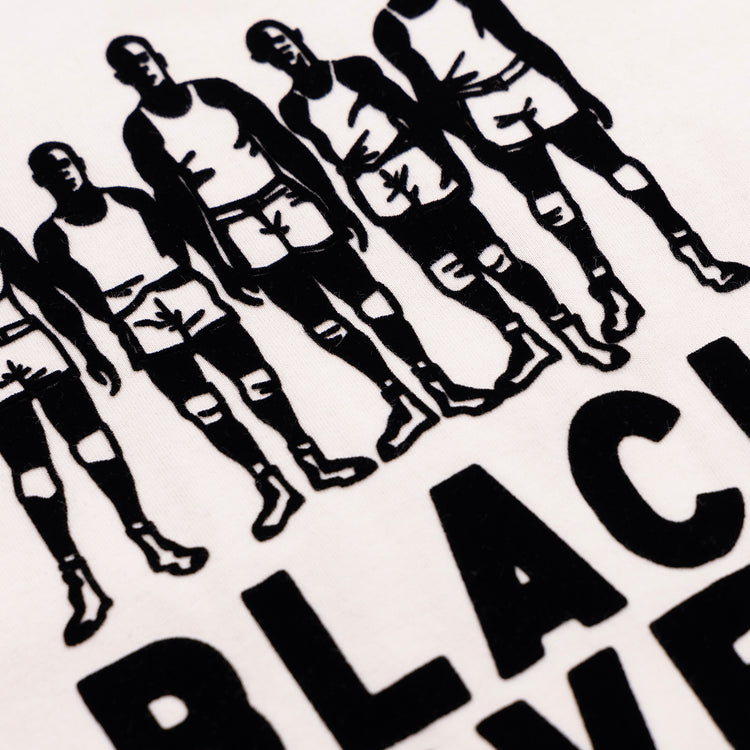 Close-up of a printed design on a white Ebbets Field Flannels Black Fives T-Shirt, featuring Black men in sportswear celebrating basketball history above large bold BLACK lettering.