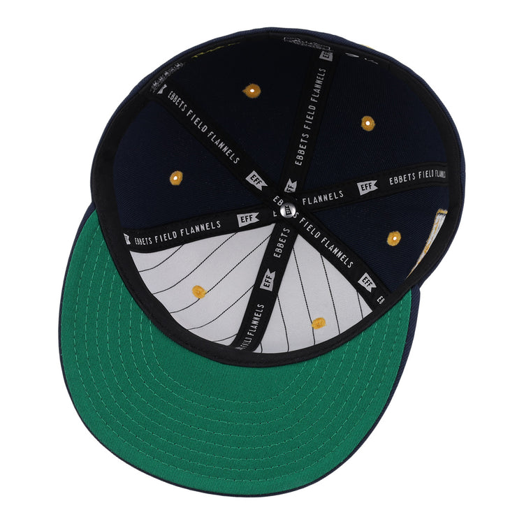 The New York Rens Fitted Ballcap by Ebbets Field Flannels is shown from below, highlighting its green underbrim, gray, white, and black interior with EBBETS FIELD FLANNELS text and gold rivets—a tribute to Black basketball history.
