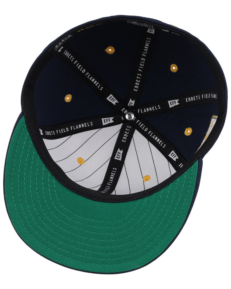 The New York Rens Fitted Ballcap by Ebbets Field Flannels is shown from below, highlighting its green underbrim, gray, white, and black interior with EBBETS FIELD FLANNELS text and gold rivets—a tribute to Black basketball history.