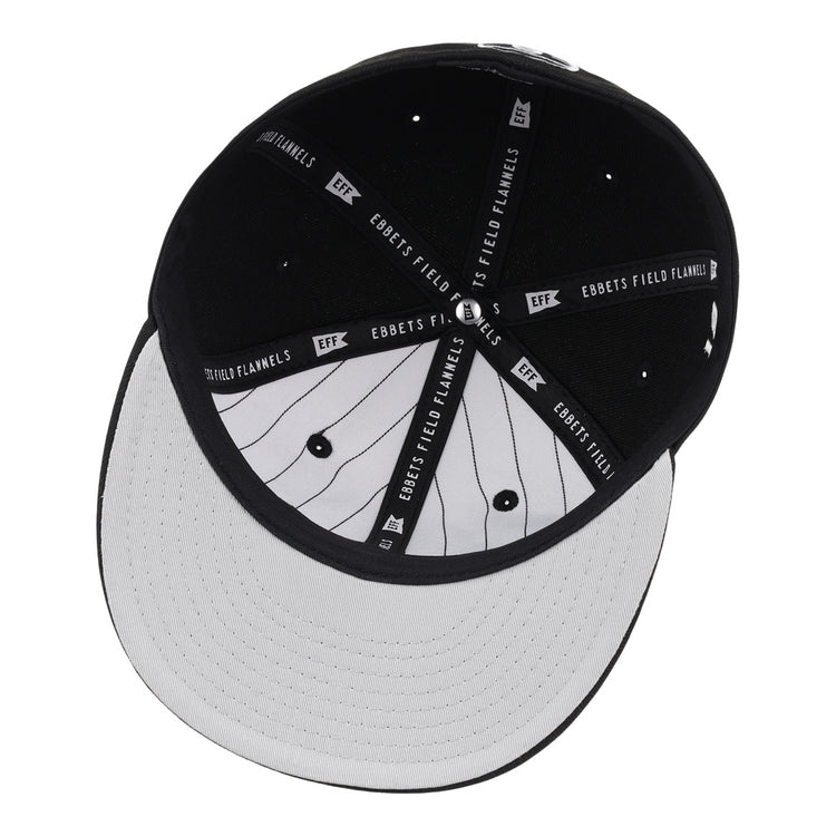 The underside of the Black Fives Fitted Ballcap by Ebbets Field Flannels features a black interior with branded fabric strips and a white brim with black pinstripes, inspired by Black Fives heritage.