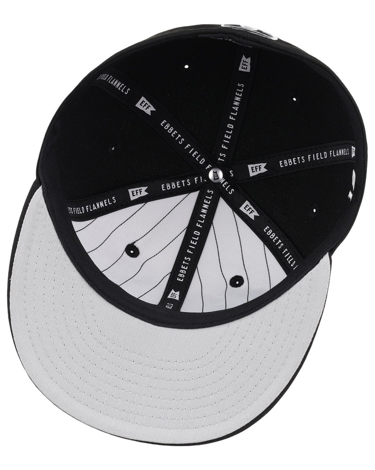 The underside of the Black Fives Fitted Ballcap by Ebbets Field Flannels features a black interior with branded fabric strips and a white brim with black pinstripes, inspired by Black Fives heritage.