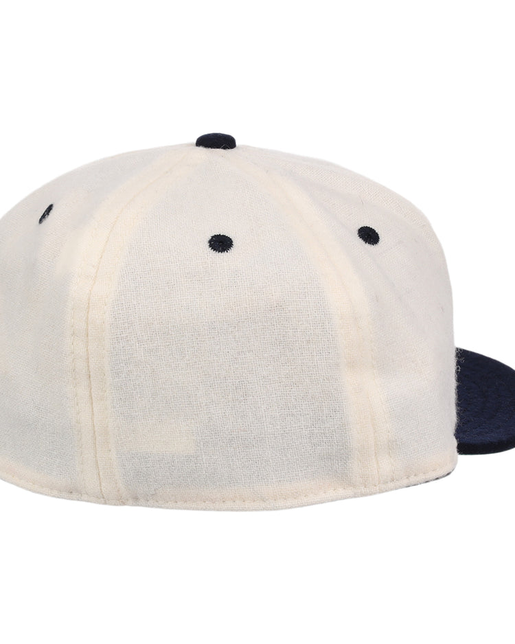 The Ebbets Field Flannels New York Rens Wool Ballcap features a dark navy brim, white panels with black stitching, vintage-inspired seams, and a round top button, shown from the back.