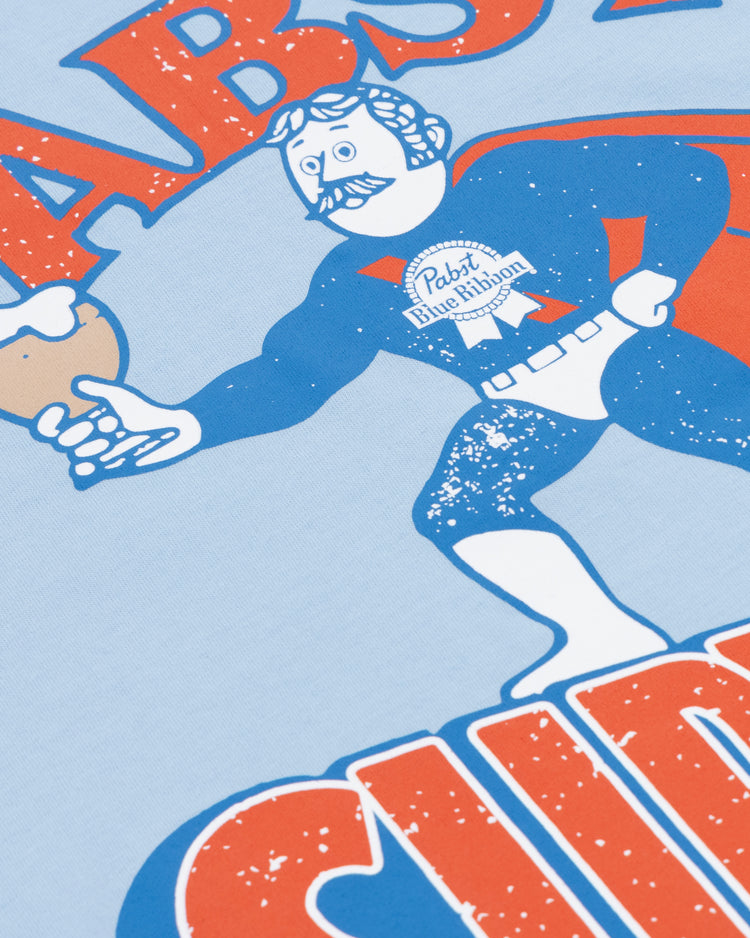 A cartoon superhero with a mustache wears the PBR EFF Vintage Beer T-Shirt by Ebbets Field Flannels, showing off the Pabst Blue Ribbon logo and holding a beer mug, with bold red and orange text celebrating classic Milwaukee brew.