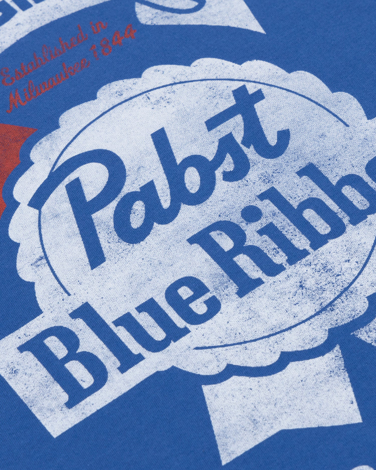 Close-up of the PBR EFF Vintage Beer T-Shirt in royal blue by Ebbets Field Flannels, featuring a distressed vintage-style Pabst Blue Ribbon logo with white and red accents and Established in Milwaukee 1844.