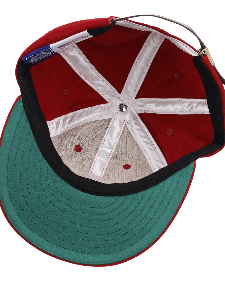 The Old Milwaukee EFF Vintage Beer Wool Ballcap by EFF features a red wool design, green underbrim, white interior seams, silver center button, and an adjustable brown strap—a classic pick for fans of vintage American Lager style.