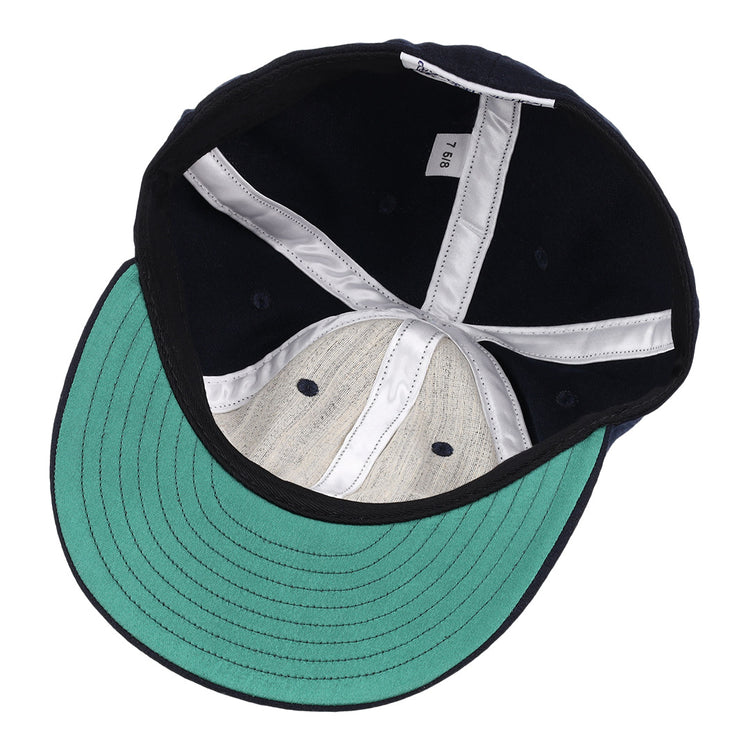 An inside view of the EFF University of Nevada Wolf Pack Collegiate Wool Ballcap, showcasing navy blue wool, a green underbrim, white internal stitching, and a size tag labeled 7 5/8.
