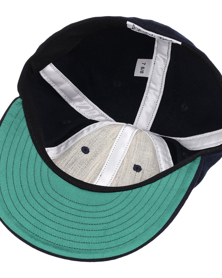 The image shows the inside of an EFF Cal State Fullerton 1965 Vintage Ballcap with a green brim, white lining, white inner tag labeled 7 5/8, navy blue crown, and light gray genuine wool interior.