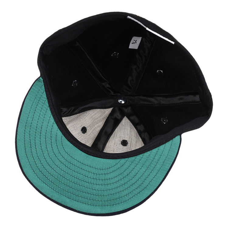 A look inside the black and green EFF New York Black Yankees Gilded Collection Ballcap shows stitching, inner seams, eyelets, and a 7 1/4 size tag—echoing classic Negro National League styles.