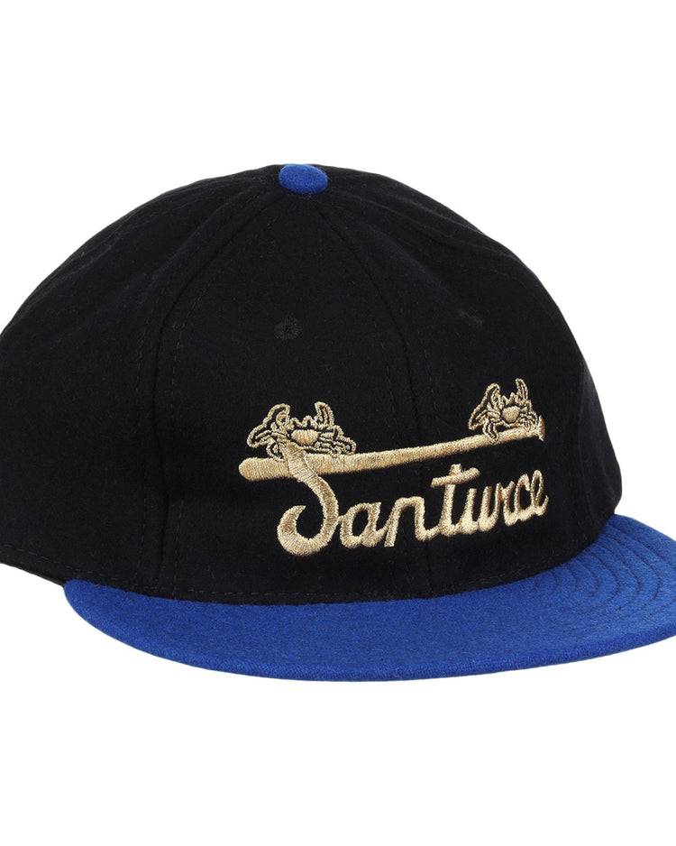 The EFF Santurce Cangrejeros Gilded Collection Ballcap features a black crown, blue brim, gold scroll details, and Santwoz gold script embroidery—a striking nod to the Puerto Rico League.