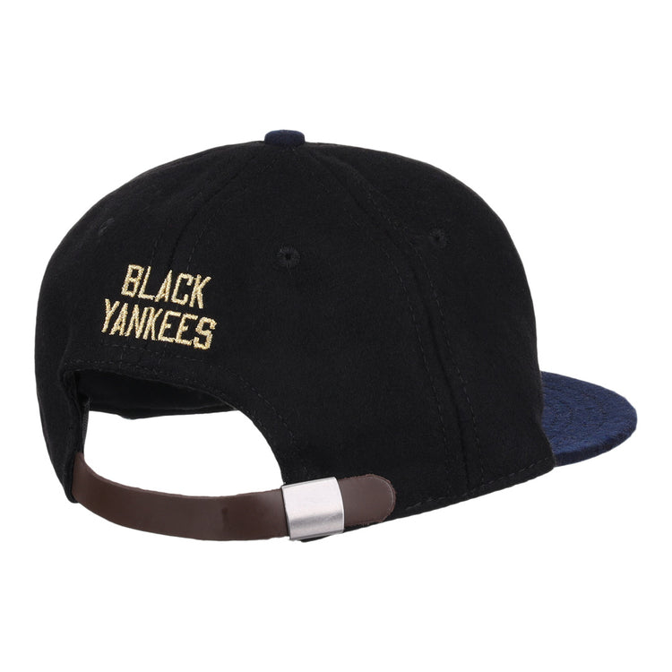 The EFF New York Black Yankees Gilded Collection Ballcap features yellow embroidered lettering above an adjustable brown strap on a black vintage design, with a dark blue brim—honoring the Negro National League.