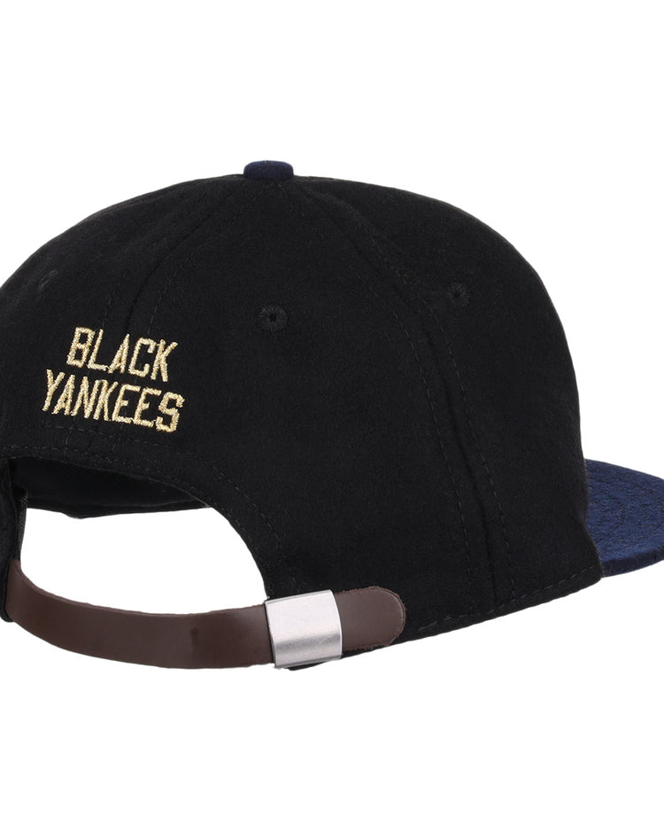 The EFF New York Black Yankees Gilded Collection Ballcap features yellow embroidered lettering above an adjustable brown strap on a black vintage design, with a dark blue brim—honoring the Negro National League.