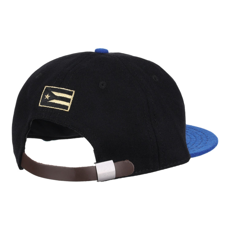 The EFF Santurce Cangrejeros Gilded Collection Ballcap is black with a blue brim, seen from the back. It has an adjustable brown strap and a small gold and white flag detail on the left side, inspired by Puerto Rico League heritage.