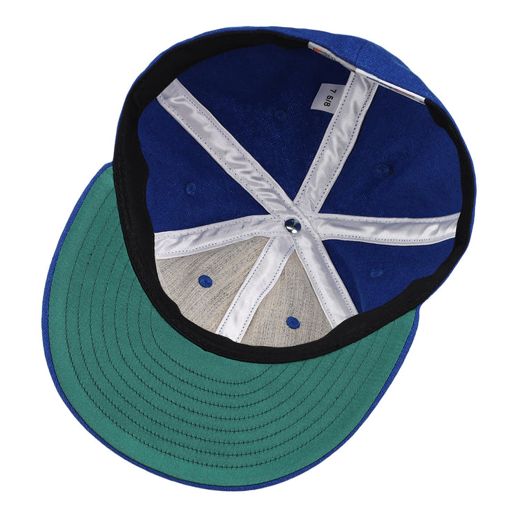 The image shows the inside view of an EFF Royal Ponciana Giants 1912 Vintage Ballcap in blue wool with a green brim, size tag 7 1/8, white and black lining, exposed stitching, and classic hotel league baseball styling.