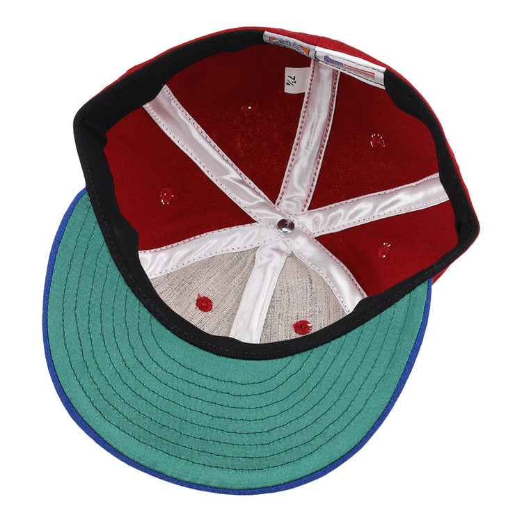 The image shows the inside of an EFF Memphis Red Sox 1946 Vintage Ballcap, featuring a green brim, red crown, white stitching and panels, black inner band, and a size tag reading 7 1/4—a tribute to the classic Negro American League style.