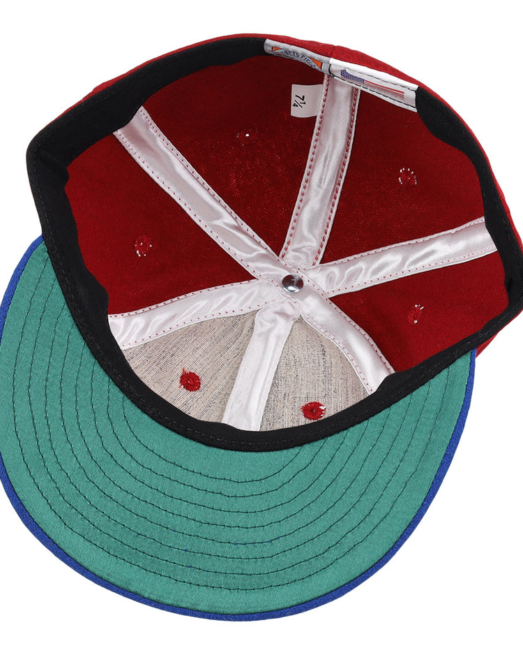 The image shows the inside of an EFF Memphis Red Sox 1946 Vintage Ballcap, featuring a green brim, red crown, white stitching and panels, black inner band, and a size tag reading 7 1/4—a tribute to the classic Negro American League style.