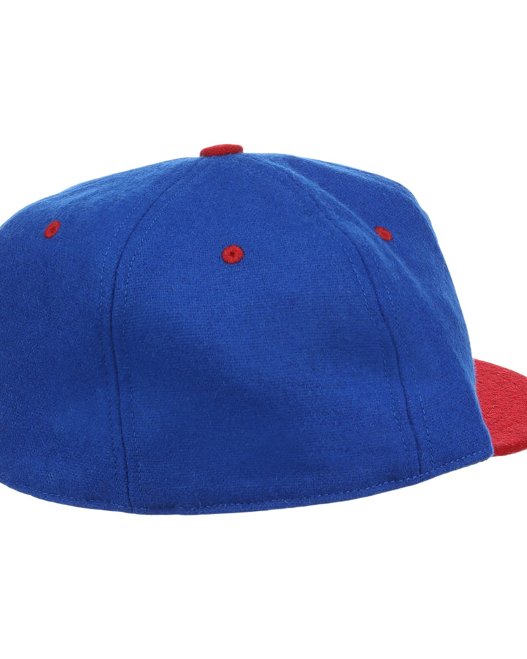 The EFF Nashville Cubs 1946 Vintage Ballcap features blue wool with a red brim, top button, and eyelets—modeled after the 1946 Negro Southern League cap—shown from a rear side angle on a white background.