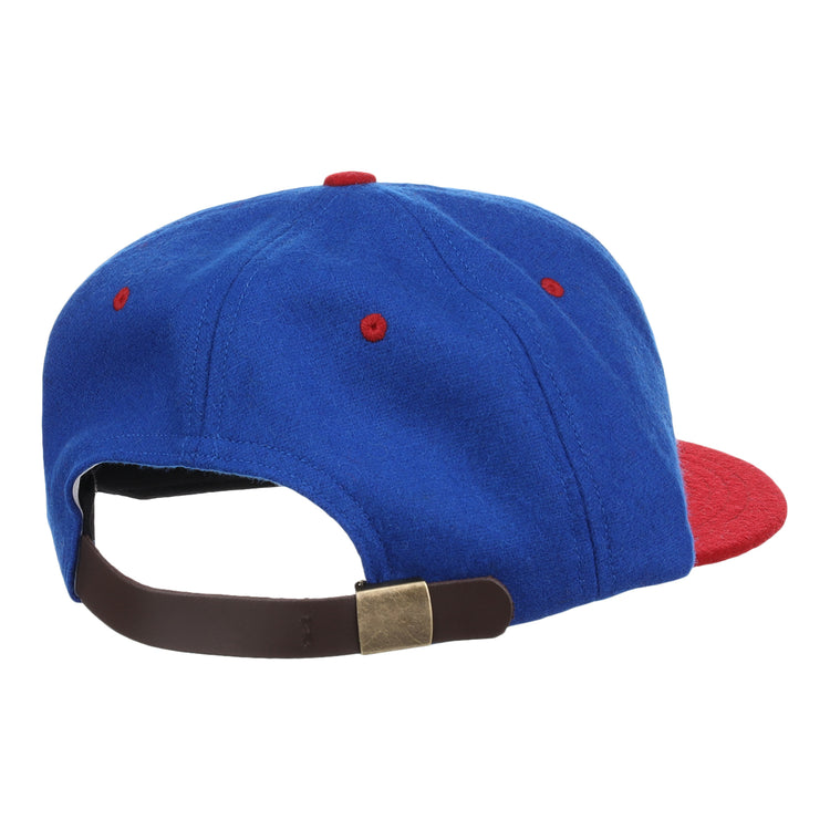 The EFF Nashville Cubs 1946 Vintage Ballcap, shown from the back, is blue with a red brim and red stitching accents. Made of vintage wool, it features an adjustable brown strap with a brass-colored buckle.