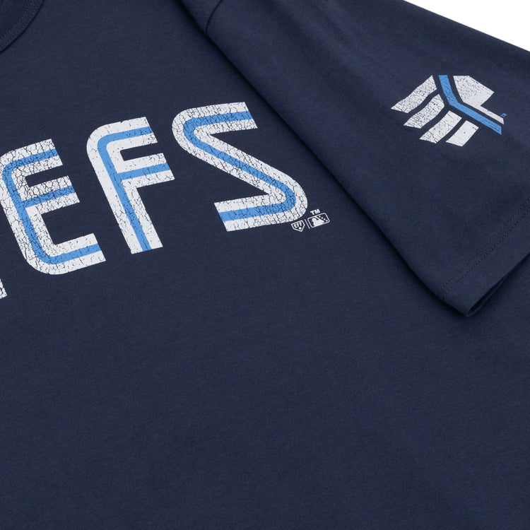 Close-up of a navy blue Ebbets Field Flannels Syracuse Chiefs EFF MiLB Vintage T-Shirt, featuring distressed white and blue text and a geometric sleeve logo—classic throwback apparel for International League fans.