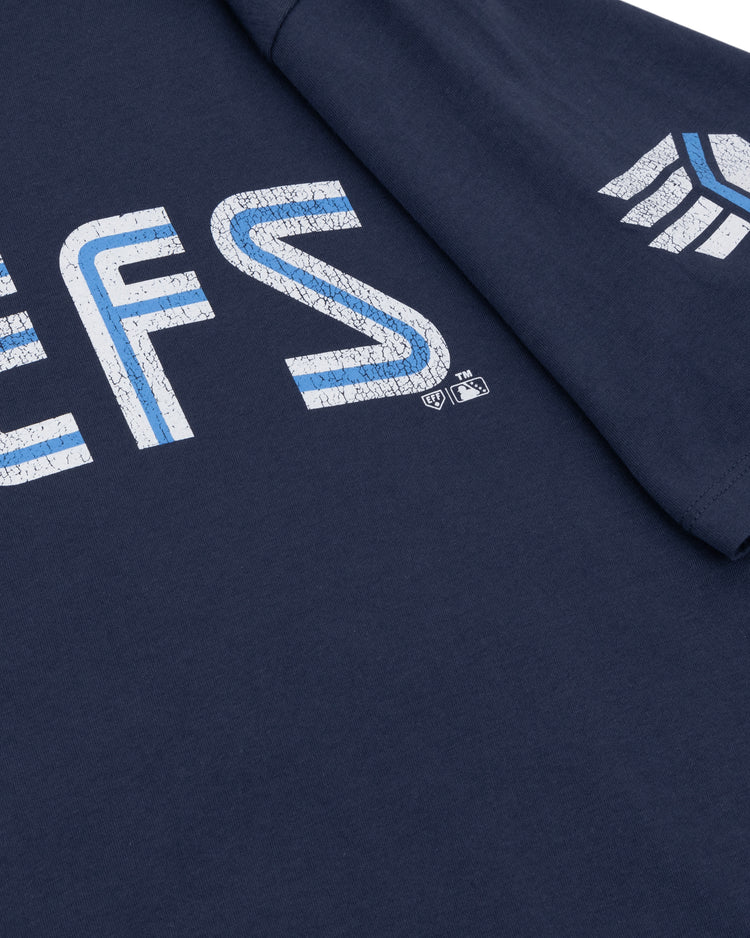 Close-up of a navy blue Ebbets Field Flannels Syracuse Chiefs EFF MiLB Vintage T-Shirt, featuring distressed white and blue text and a geometric sleeve logo—classic throwback apparel for International League fans.