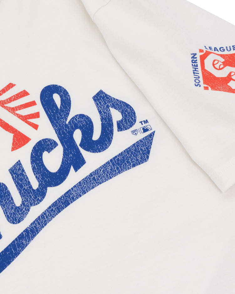 The Ebbets Field Flannels Memphis Chicks EFF MiLB Vintage T-Shirt features bold blue “Chicks” text with red accents, a sleeve logo in red and blue, and is crafted from premium cotton for lasting comfort.
