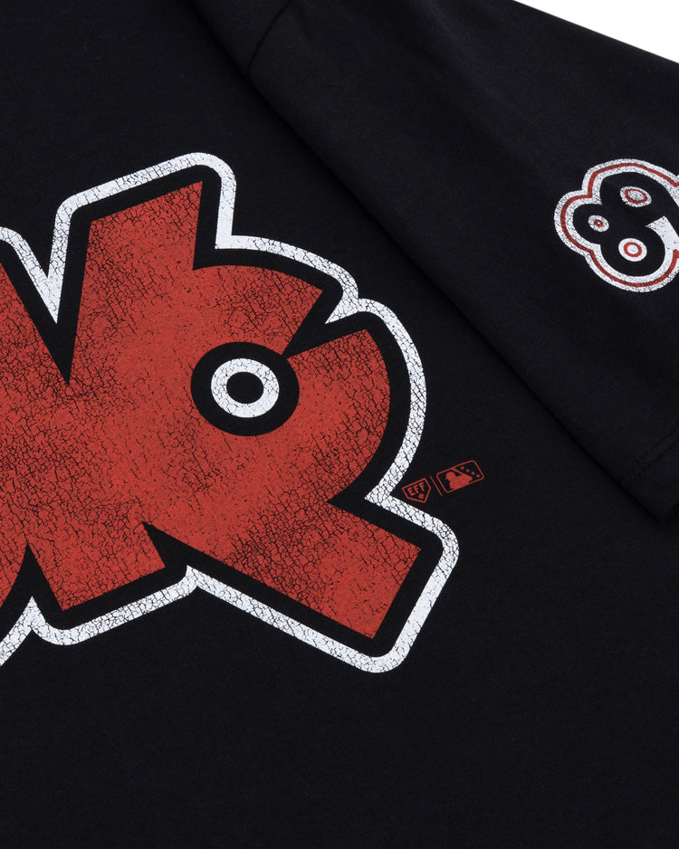 A close-up of the Ebbets Field Flannels Oklahoma City 89ers EFF MiLB Vintage T-Shirt in black premium cotton, with a large cracked-texture red and white chest graphic and a small “89ers” sleeve patch, inspired by Vintage Minor League tees.