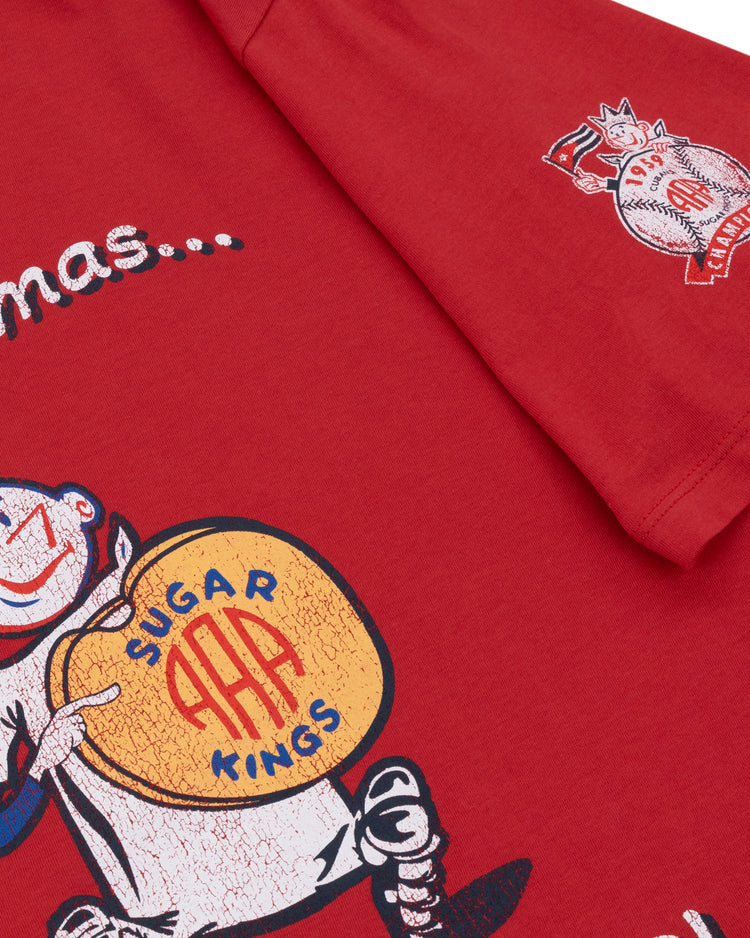 The Ebbets Field Flannels Havana Sugar Kings EFF MiLB Vintage T-Shirt is a premium red cotton tee with a vintage cartoon of a smiling character holding a yellow drum, inspired by Havana baseball history, with AAA Camiseta and sleeve crest details.