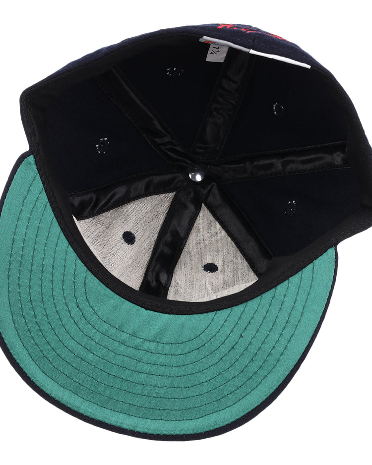 An inside view of the EFF Tampa Tarpons Letterhead Wool Vintage Ballcap, featuring a green underbrim, black interior seams, gray sweatband, and visible size tag—shown upside down with the crown facing up.