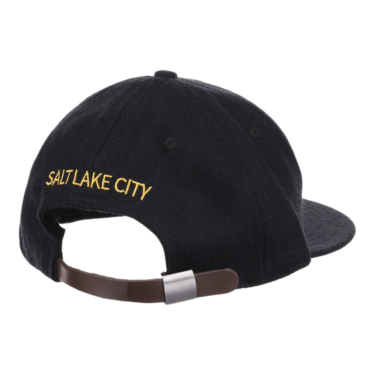 The EFF Salt Lake City Bees Letterhead Wool Vintage Ballcap is a black cap seen from the back, with yellow SALT LAKE CITY embroidery above an adjustable brown strap and metal clasp, echoing classic Minor League baseball styles.