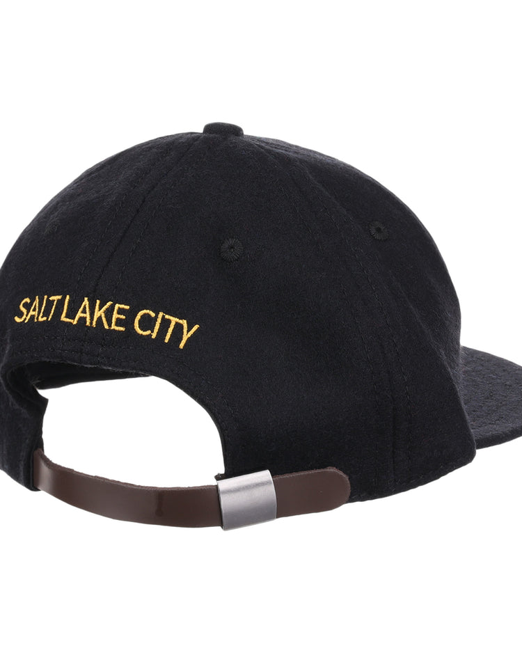 The EFF Salt Lake City Bees Letterhead Wool Vintage Ballcap is a black cap seen from the back, with yellow SALT LAKE CITY embroidery above an adjustable brown strap and metal clasp, echoing classic Minor League baseball styles.