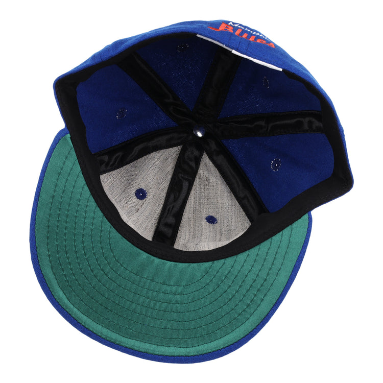 The EFF Memphis Blues Letterhead Wool Vintage Ballcap is shown inside out, revealing its blue wool fabric, green underbrim, black inner seams, and gray panels—a classic look inspired by vintage Texas League ballcaps.
