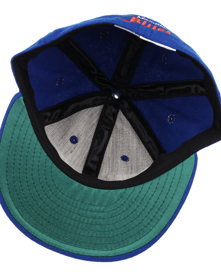 The EFF Memphis Blues Letterhead Wool Vintage Ballcap is shown inside out, revealing its blue wool fabric, green underbrim, black inner seams, and gray panels—a classic look inspired by vintage Texas League ballcaps.