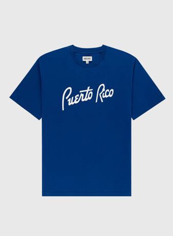 The Ebbets Field Puerto Rico 1958 National Team Short Sleeve Tee features “Puerto Rico” in white script, honoring Roberto Clemente and the 1958 Caribbean Series, shown on a plain light gray background.