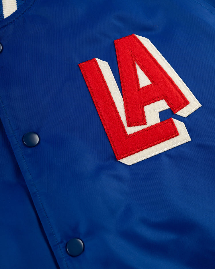 A close-up of the Ebbets Field Los Angeles Angels (PCL) Satin Varsity Jacket, featuring dark buttons and a bold red and white LA patch on the front, capturing classic team spirit.