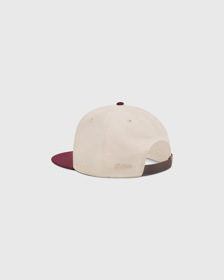 The Ebbets Field Texas A&M Sarge Cotton Twill Ballcap features a beige cotton twill design with a burgundy brim and is shown from the back. It includes a brown adjustable strap and subtle beige embroidery above the strap, creating a timeless look ideal for Texas A&M University fans.