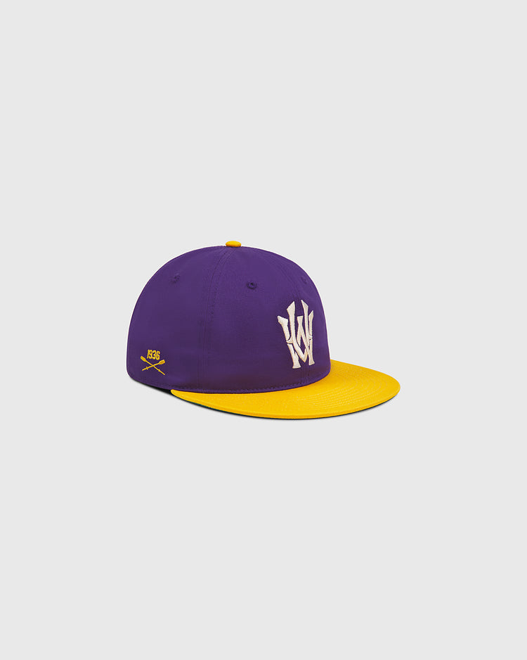 Ebbets Field University of Washington Cotton Twill Classic Cap in purple with a yellow brim and button, featuring a white embroidered W on the front and a small yellow crossed bats and “359” detail on the side. The cap is shown against a plain light background.