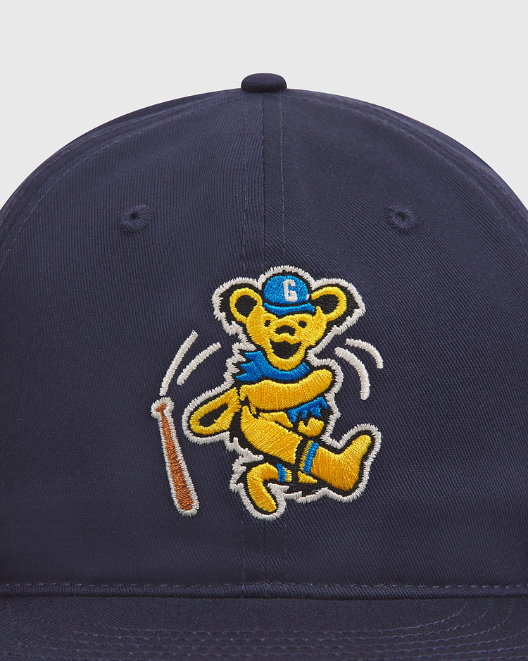 The Ebbets Field Grateful Dead Baseball Bear Cotton Twill Ballcap features a navy blue cotton twill design with an embroidered cartoon bear in a blue hat and uniform swinging a brown baseball bat.