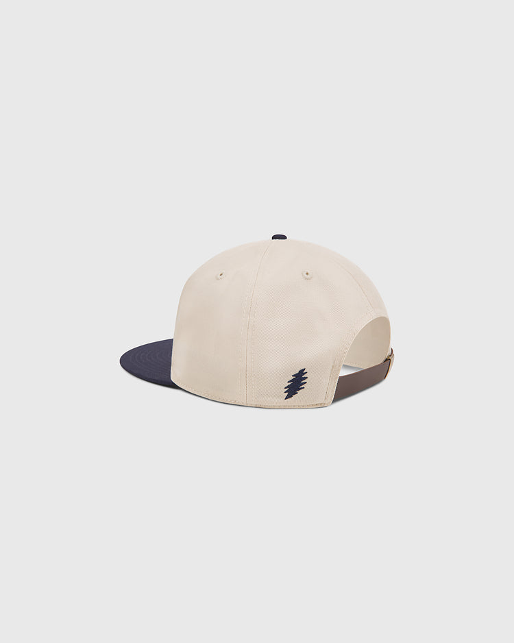 An Ebbets Field Grateful Dead Baseball Bear Cotton Twill Ballcap in beige, shown from the back. This hat features a navy brim and a small dark zigzag logo above the adjustable brown strap, offering a subtle tribute to classic Grateful Dead ballcap styles.