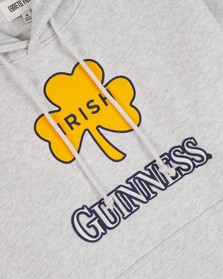 Show off your Irish heritage with the Notre Dame X Guinness Heavyweight Pullover Hoodie from Ebbets Field—a gray hoodie featuring a yellow shamrock labeled “IRISH” and bold black and white “GUINNESS” lettering beneath it.